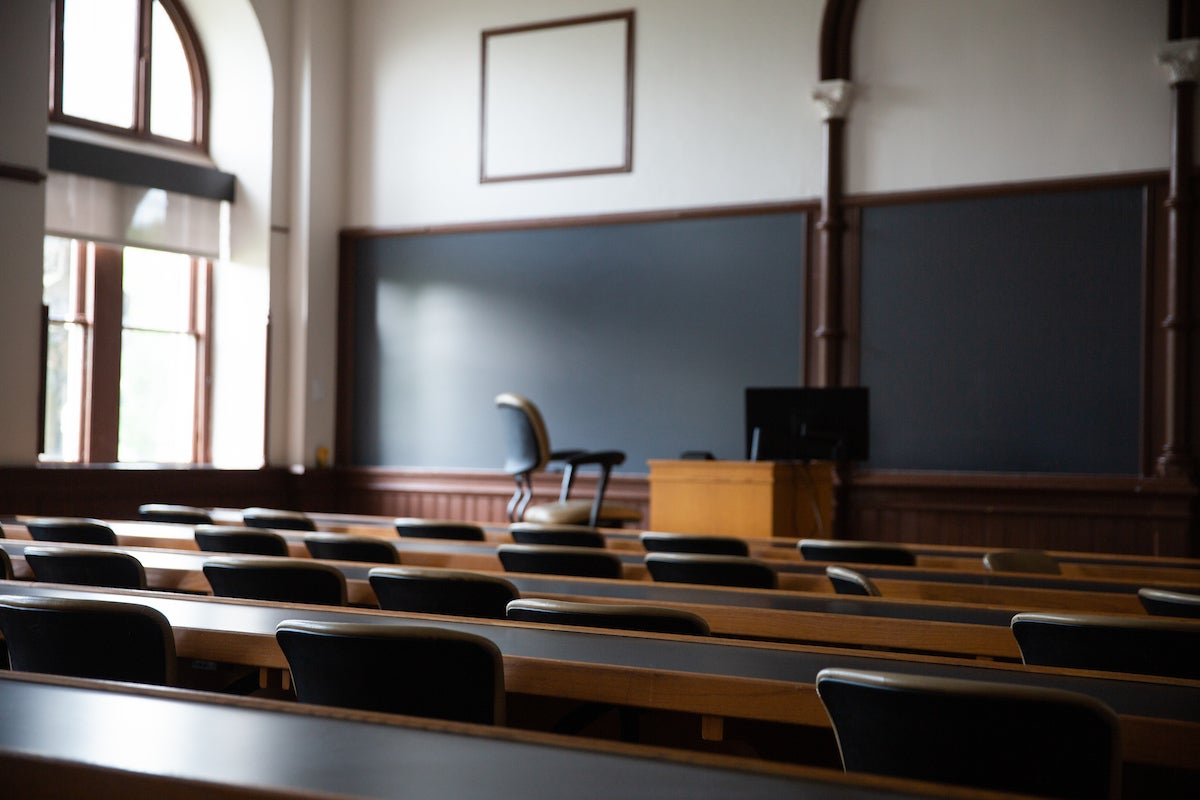 Rows of desks inside an empty classroom.