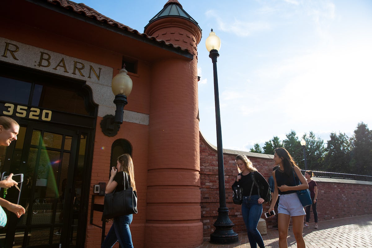 Students walking in front of the Car Barn building entrance.