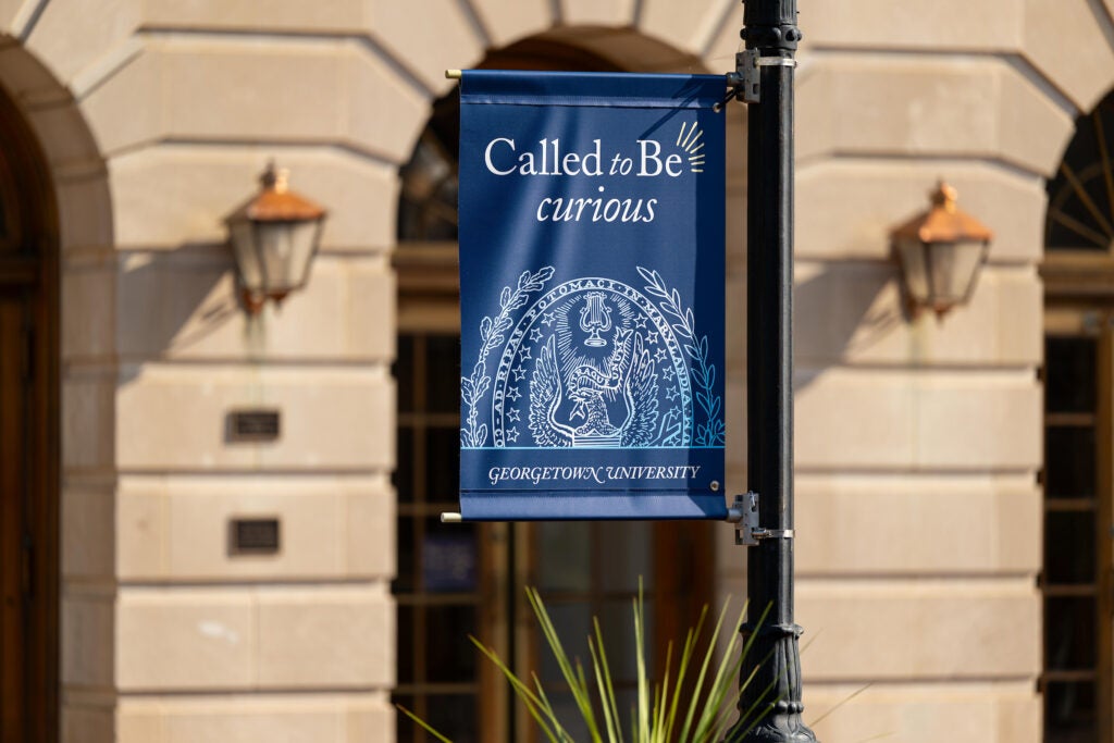 "Called to be Curious" signage on campus with the Georgetown Seal and logo.